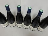 six bottles of wine are lined up on a table
