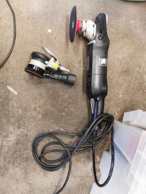 an image of a corded sander sitting on the ground next to other tools