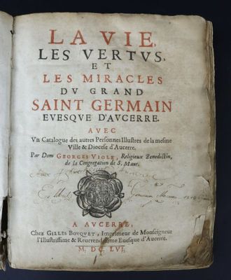 an old book with writing on it sitting on top of a table