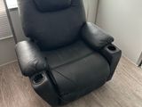 un fauteuil inclinable noir qui se trouve dans une pièce