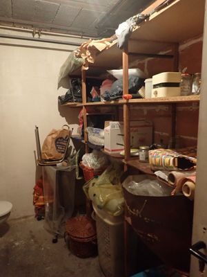 une pièce équipée de toilettes, d'une poubelle et d'une étagère remplie d'objets