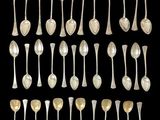 an assortment of silver spoons and spoon spoons on a black background