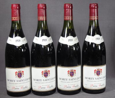 quatre bouteilles de vin sont alignées sur une table