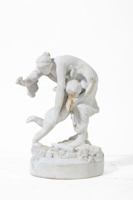 une statue représentant un homme aux prises avec une femme, posée sur une surface blanche
