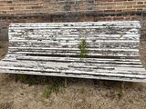 a wooden bench sitting in front of a brick wall
