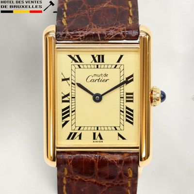 gros plan d'une montre-bracelet en or avec des chiffres romains