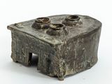 un petit objet métallique posé sur une surface blanche