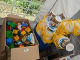 une boîte remplie de jouets et une boîte de tasses posées sur une table