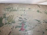 an old wooden box with paint on it sitting on a table