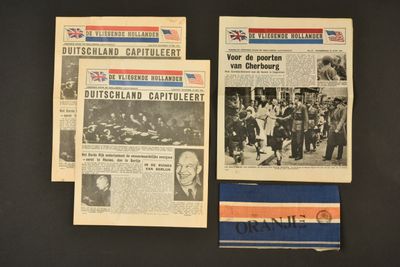 trois vieux journaux sont exposés sur une surface noire