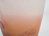a glass vase with a pink and white design on it