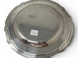 a silver plate on a white surface with a tag on it