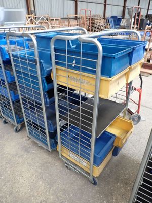 de nombreux bacs bleus et jaunes posés sur un chariot dans un entrepôt