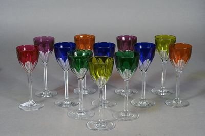 seven wine glasses with different colors in them on a table