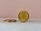 a gold coin sitting on top of a white counter next to a pink wall