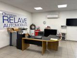 un bureau sur lequel se trouve un ordinateur, dans une pièce où est accrochée une affiche au mur