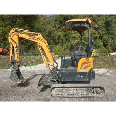 a picture of a small excavator parked in a gravel lot