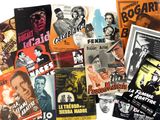 De nombreuses affiches de films anciens sont exposées sur un fond blanc.