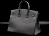a close up of a black handbag on a black surface