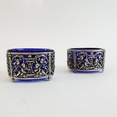 pair of silver and blue glass bowls on a white surface