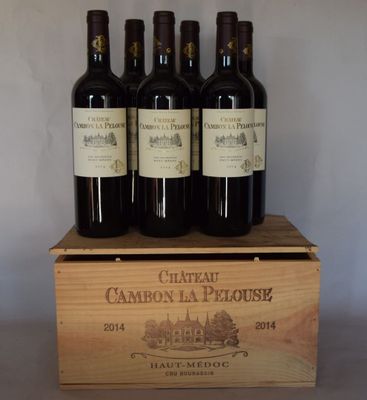 quatre bouteilles de vin rouge dans un coffret en bois posé sur une table