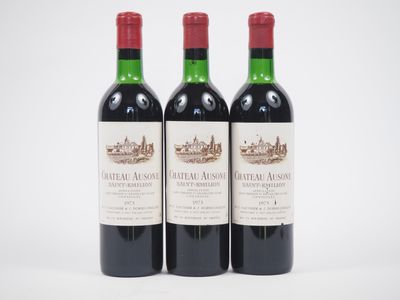 trois bouteilles de vin rouge posées l'une à côté de l'autre sur une surface blanche