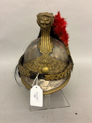 an old helmet with a red feather on top of it