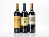 three bottles of wine are lined up on a white surface