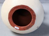 a white vase with a brown rim sitting on a table
