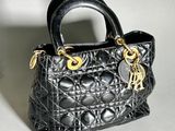 a small black purse with a gold chain on it