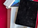 une boîte contenant un stylo, un appareil photo et une tablette, posée sur une table