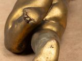 a bronze statue of a baby laying on its back