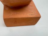 a clay bowl sitting on top of a wooden block