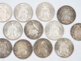 a group of silver coins sitting on top of a white surface