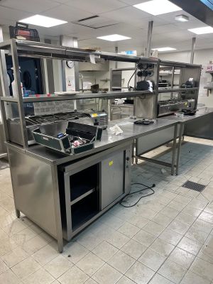 une cuisine avec de nombreux plans de travail en inox