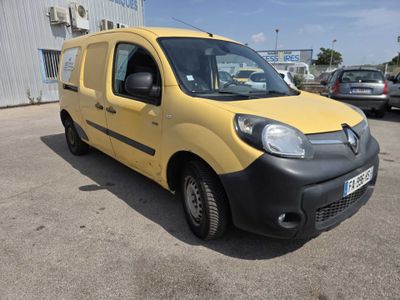 the small yellow van is parked in front of a building
