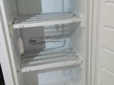 a small white refrigerator that is open on the floor