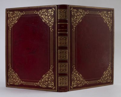 un vieux livre à la couverture rouge et à la bordure dorée