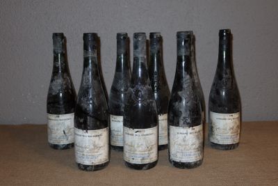 six bouteilles de vin sont alignées sur une table