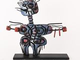 sculpture représentant un homme tenant un couteau et une fourchette, posée sur un socle noir