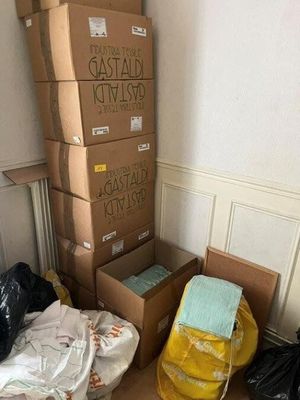 une pile de cartons posée par terre dans un coin de la pièce