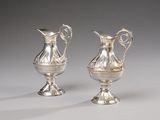 two silver vases with handles and handles on a white surface