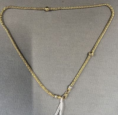 un collier en or orné d'un pompon sur un mannequin, un mannequin, un mannequin, un mannequin, un mannequin, un mannequin, un mannequin, un manne