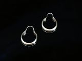 une paire de boucles d'oreilles créoles en argent sur fond noir