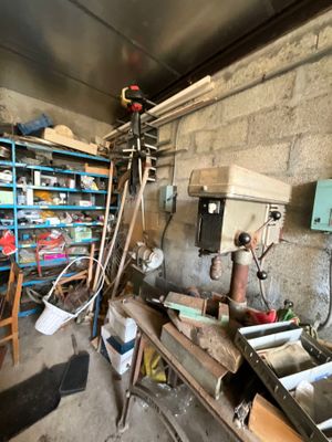 une photo d'un garage encombré d'objets et d'outils