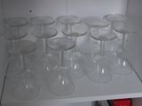 de nombreux verres à vin vides posés sur une étagère dans un placard