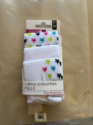 trois paires de chaussettes blanches ornées d'étoiles colorées