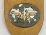 a wooden plaque with a picture of a plane on it