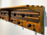 a wooden coat rack with black knobs on it
