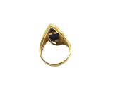 a close up of a gold ring with a black stone